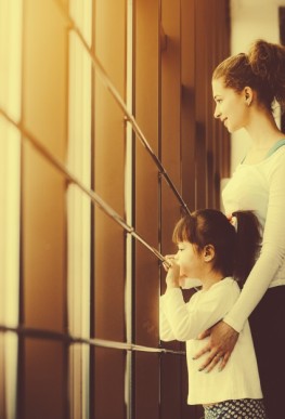 smiling-mother-with-her-daughter-looking-through-the-window_1153-642